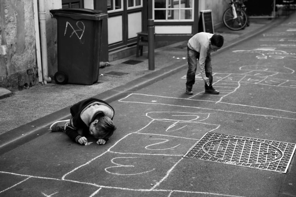 enfants dessinant sur le sol de la rue