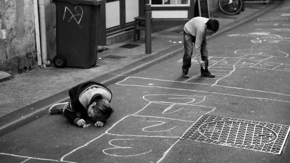 enfants dessinant sur le sol de la rue